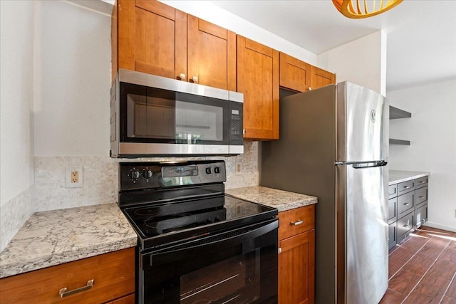 kitchen featuring stainless steel appliances, brown cabinetry, backsplash, and dark wood-style floors