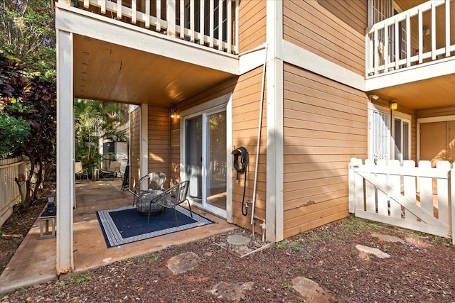 view of patio with a balcony and fence