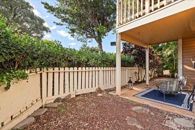 view of yard featuring a balcony, a fenced backyard, and a patio