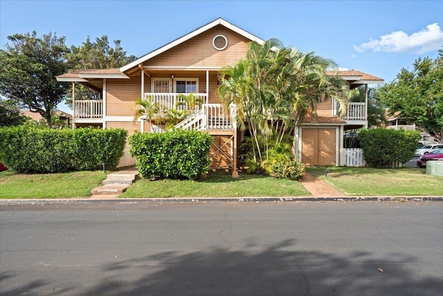 view of front facade with stairway and a front lawn