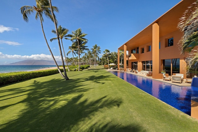 pool with a beach view, a lawn, a patio area, and a water view