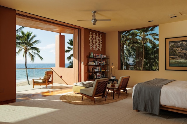 bedroom featuring a water view, wood finished floors, and floor to ceiling windows