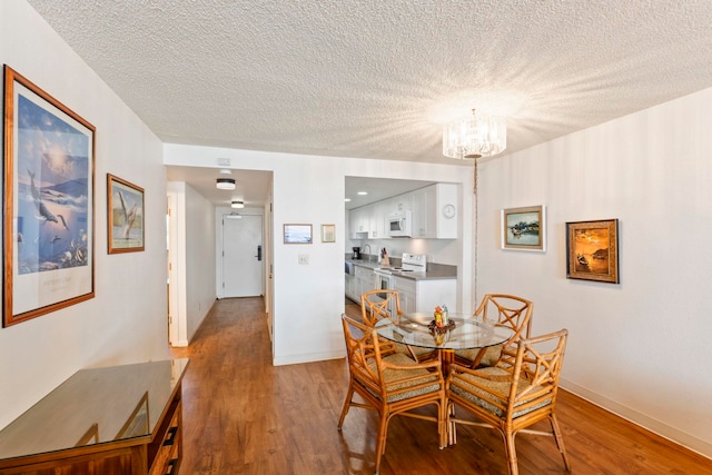 100 Hauoli St Unit 303, Wailuku, HI 96793 - dining space featuring wood finished floors, a chandelier, and a textured ceiling