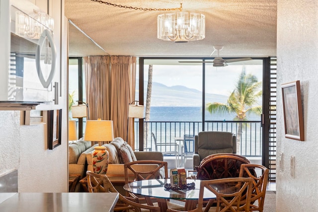 100 Hauoli St Unit 303, Wailuku, HI 96793 - dining area featuring floor to ceiling windows, a textured wall, a textured ceiling, a chandelier, and a water view