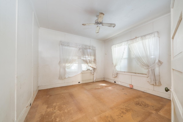 spare room with ceiling fan, concrete floors, and ornamental molding