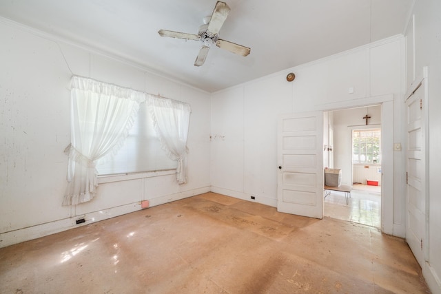 spare room featuring ornamental molding, ceiling fan, and concrete flooring