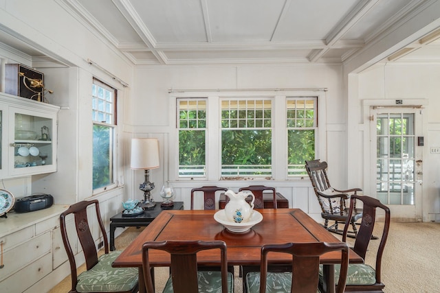 dining room with coffered ceiling, light colored carpet, a healthy amount of sunlight, and a decorative wall