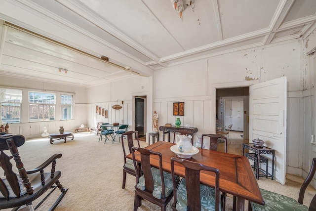 dining room featuring beam ceiling, ornamental molding, a decorative wall, and light carpet