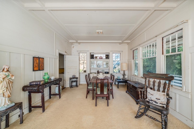 dining area with ornamental molding, light carpet, and a decorative wall