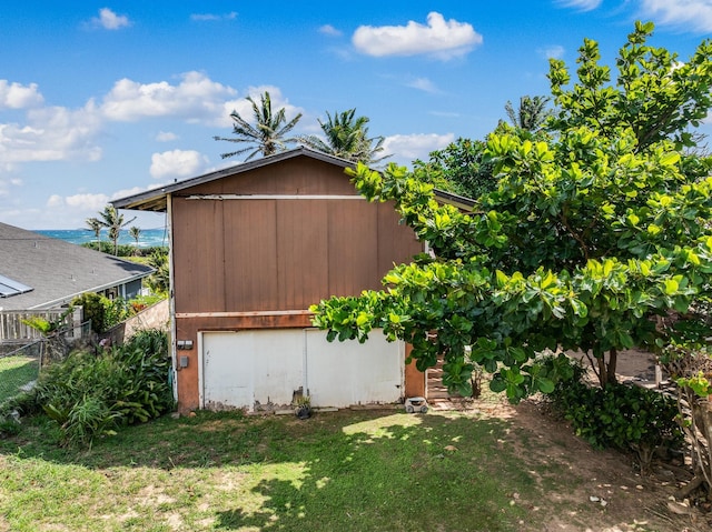 exterior space with fence, a lawn, and a garage