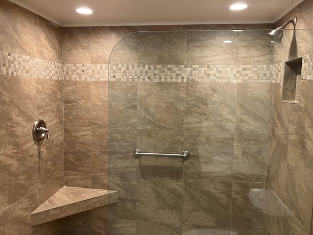 bathroom with crown molding and tiled shower