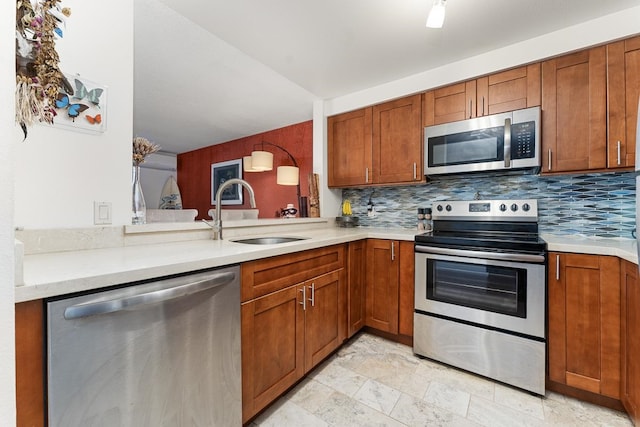 kitchen with appliances with stainless steel finishes, kitchen peninsula, sink, tasteful backsplash, and light tile flooring