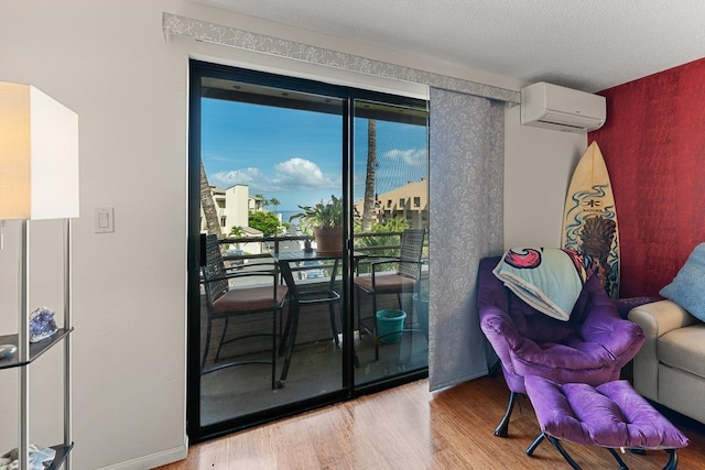 interior space with a textured ceiling, hardwood / wood-style flooring, and a wall mounted air conditioner