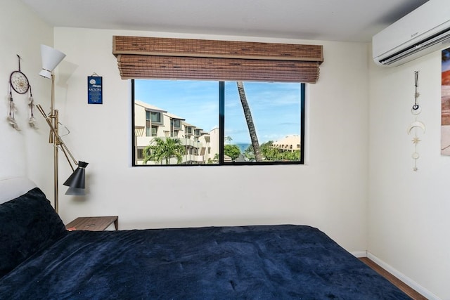 bedroom with hardwood / wood-style floors and a wall mounted air conditioner