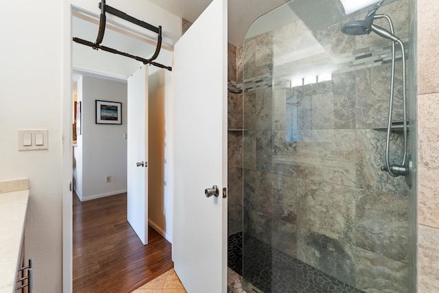 bathroom with a shower with shower door and wood-type flooring