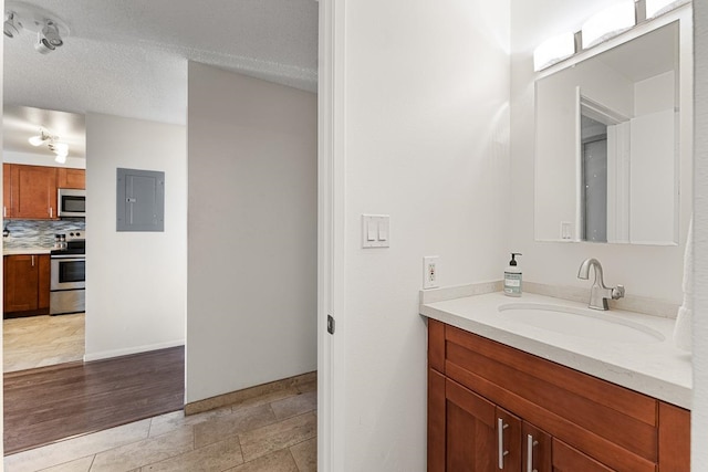 bathroom with hardwood / wood-style flooring, backsplash, vanity, and a textured ceiling