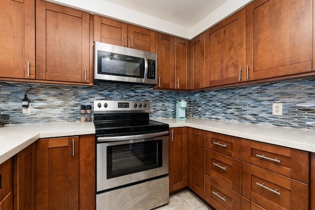 kitchen featuring stainless steel appliances, tasteful backsplash, and light tile flooring