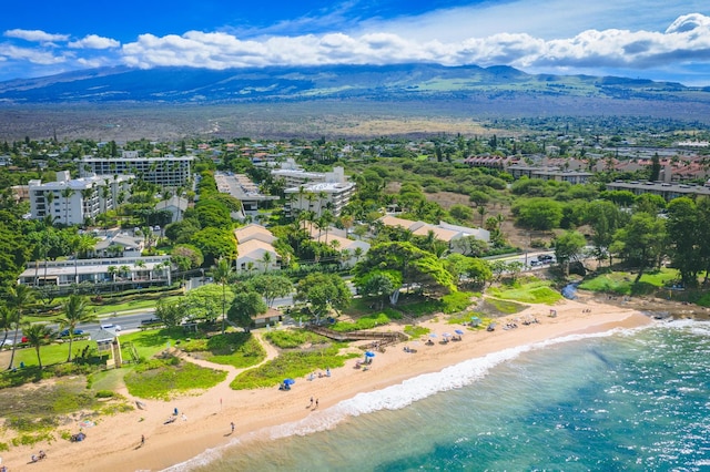 drone / aerial view featuring a water and mountain view and a view of the beach