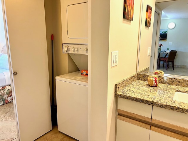 clothes washing area featuring stacked washing maching and dryer