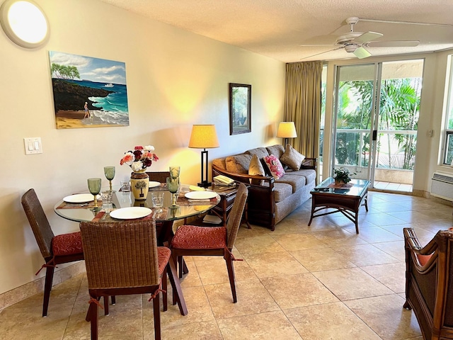 living room featuring ceiling fan, light tile patterned floors, and a textured ceiling