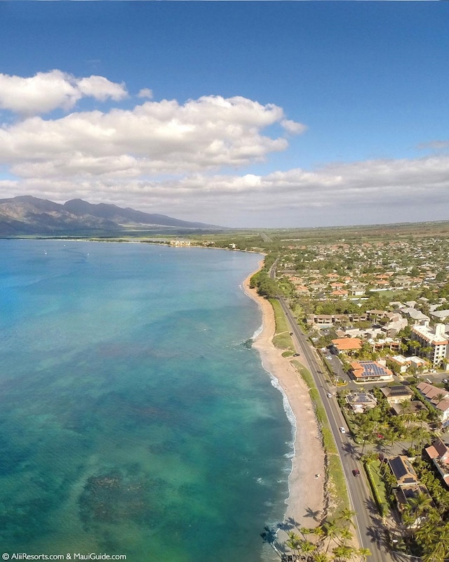 drone / aerial view featuring a water and mountain view and a view of the beach