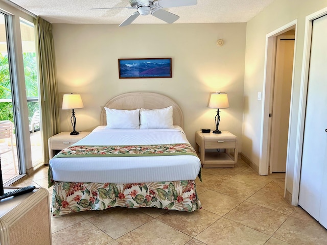 bedroom with access to outside, ceiling fan, light tile patterned flooring, and a textured ceiling