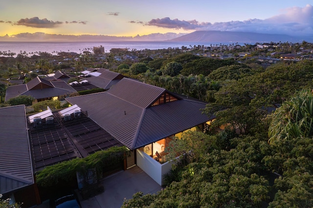 aerial view at dusk featuring a water view