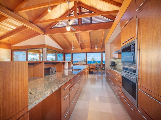 kitchen with appliances with stainless steel finishes, lofted ceiling with beams, wood ceiling, and sink