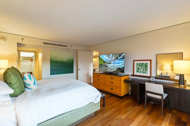 bedroom with wood-type flooring and ornamental molding