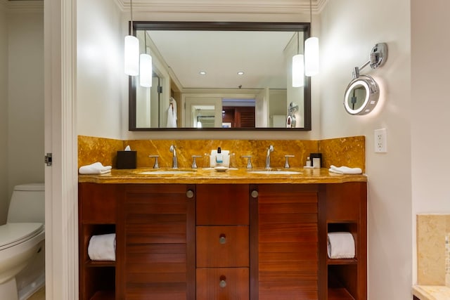 bathroom featuring backsplash, vanity, ornamental molding, and toilet