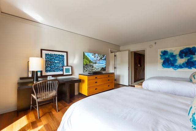 bedroom with wood-type flooring and ornamental molding