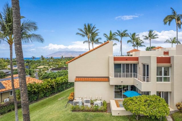 back of house with a mountain view, ac unit, and a yard