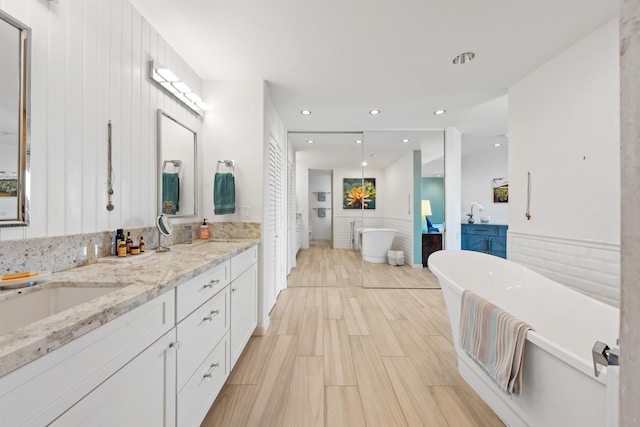 bathroom with a tub and vanity