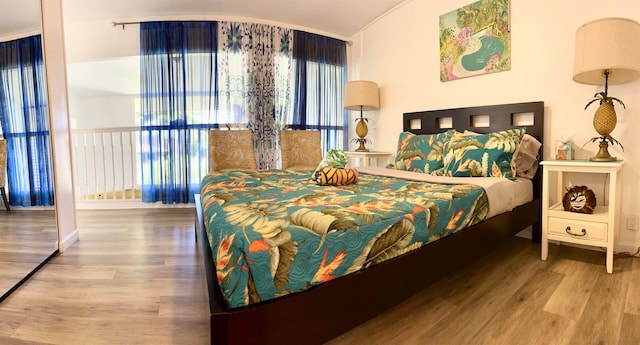 bedroom with lofted ceiling and hardwood / wood-style floors