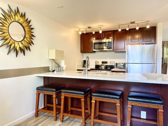 kitchen featuring a breakfast bar area, kitchen peninsula, and appliances with stainless steel finishes