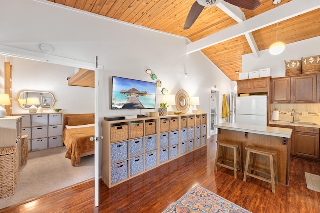 kitchen featuring a kitchen breakfast bar, a center island, white refrigerator, lofted ceiling with beams, and wooden ceiling