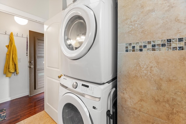 washroom featuring stacked washer and clothes dryer and tile patterned floors