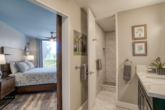 bathroom with ceiling fan, tiled shower, and vanity