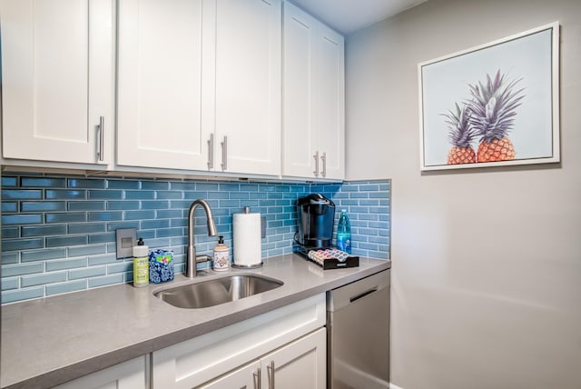 kitchen with decorative backsplash, sink, white cabinetry, and dishwasher