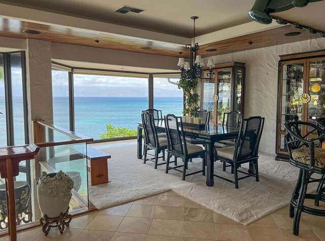 5163 Lower Honoapiilani Rd, Lahaina, HI 96761 - tiled dining space with a water view, plenty of natural light, a chandelier, a textured wall, and a raised ceiling
