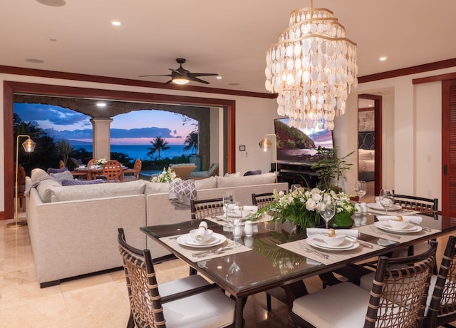 dining area featuring ceiling fan with notable chandelier and crown molding