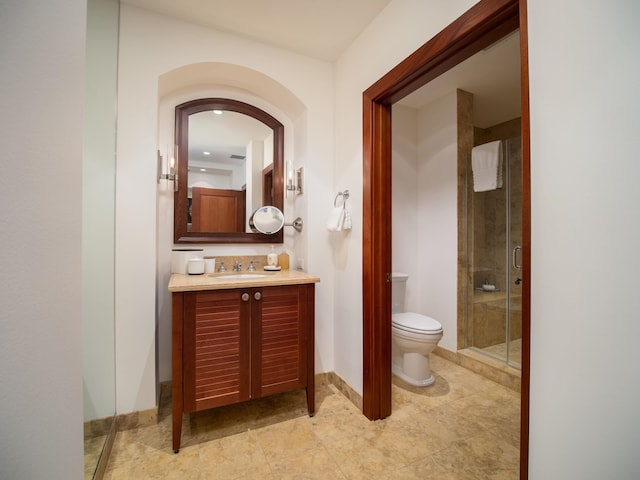 bathroom with a shower with shower door, toilet, and vanity