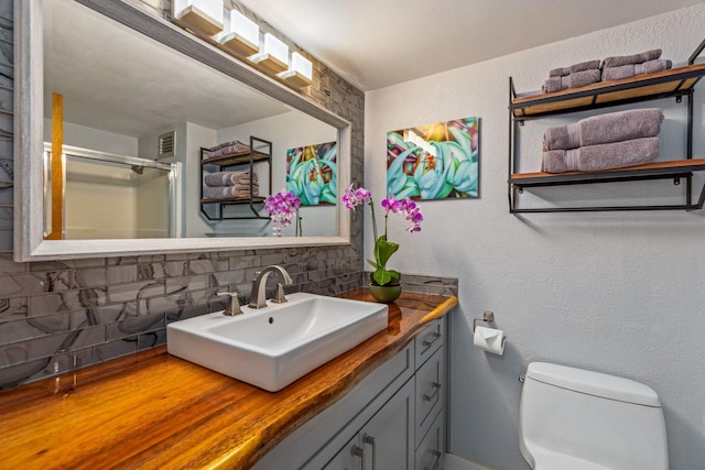 bathroom with decorative backsplash, vanity, and toilet