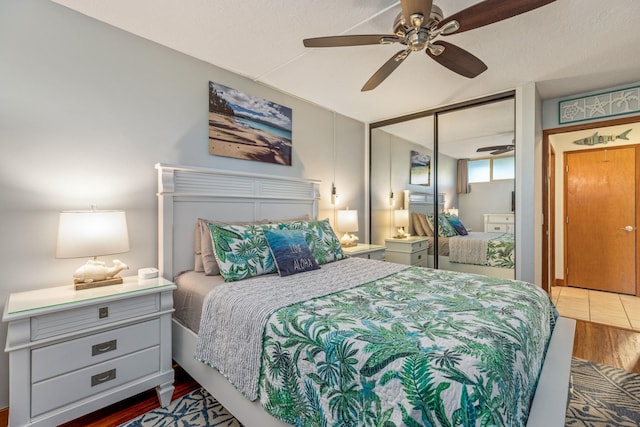 bedroom with ceiling fan, wood-type flooring, a closet, and a textured ceiling