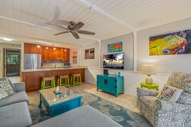 living room featuring light tile patterned flooring, wainscoting, wood ceiling, and ceiling fan