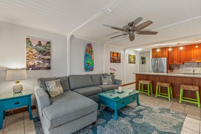 tiled living room with ceiling fan and sink