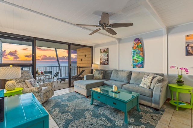 living room featuring ceiling fan, a wall of windows, wooden ceiling, light tile patterned floors, and a water view