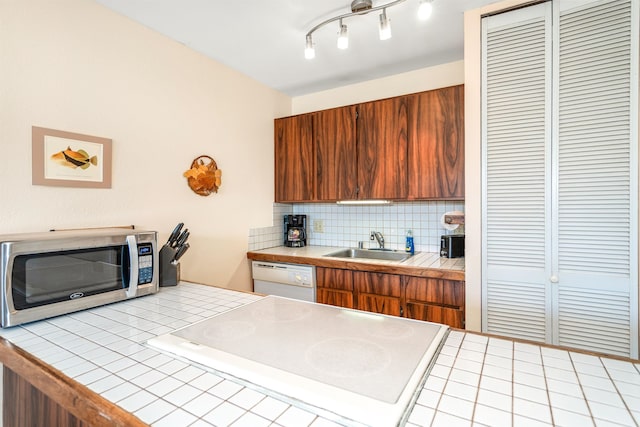 kitchen with dishwasher, backsplash, sink, and tile countertops