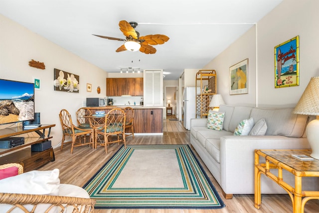 living room with light hardwood / wood-style flooring and ceiling fan