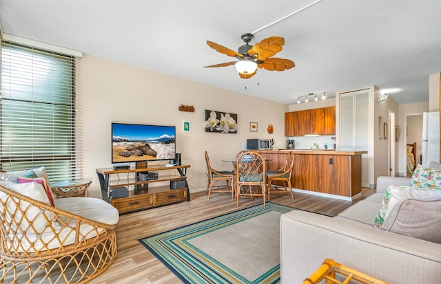 living room featuring light hardwood / wood-style flooring and ceiling fan